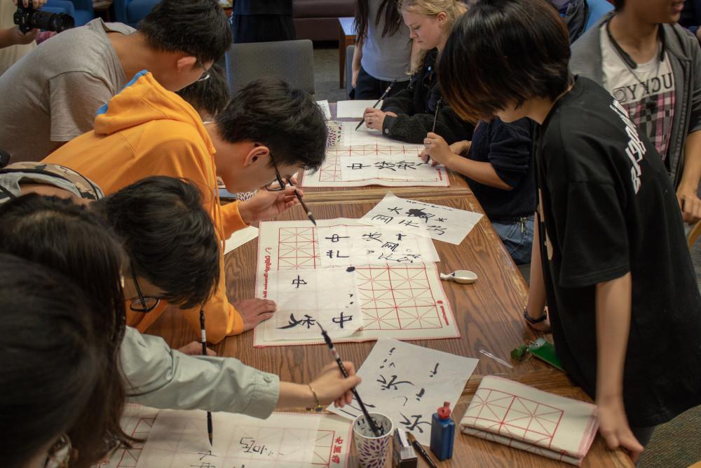 Students practice calligraphy together.